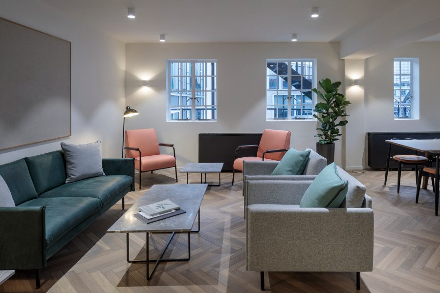 Break-out area decorated with herringbone floor tiles and modern furniture.
