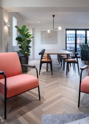 Kitchen dinning table in an office and pink chairs for the office break-out area.