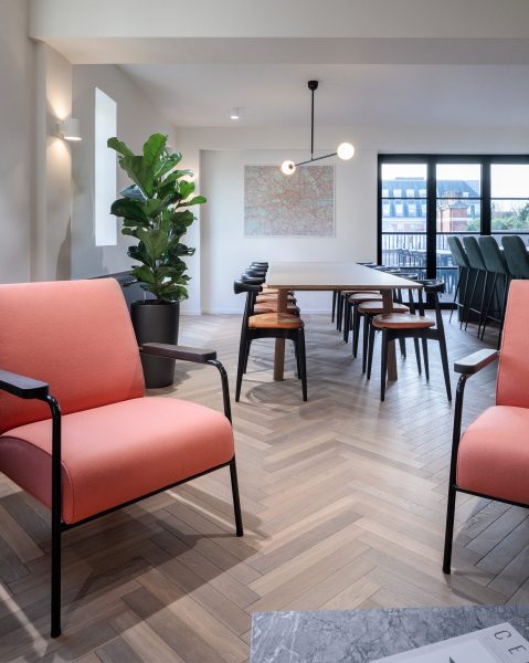 Kitchen dinning table in an office and pink chairs for the office break-out area.
