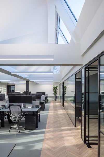 Herringbone parquet flooring in an open-plan workspace.