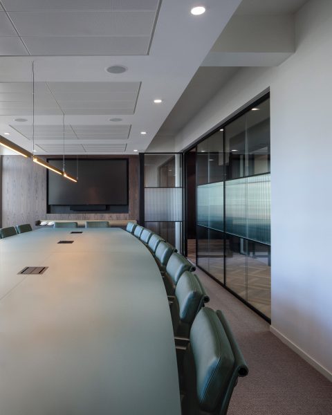 Large boardroom table and leather green chairs for an office space in London.