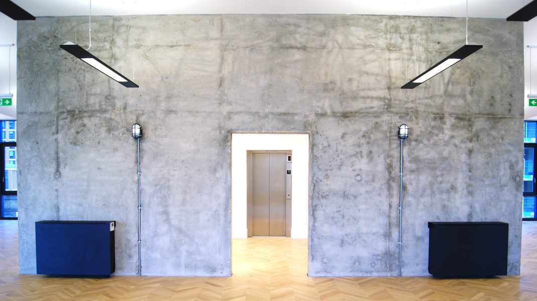 Concrete wall and industrial style lights in an office space in South Lambeth Road