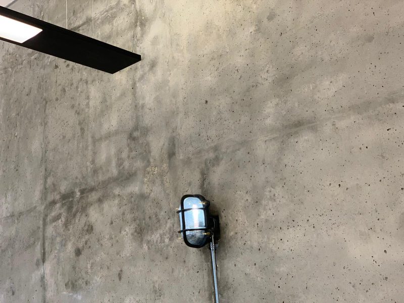 A concrete wall finish and retro light.