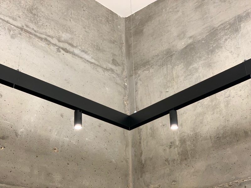 Black pendant lights and a concrete wall create a industrial look and feel for this office space, near London.
