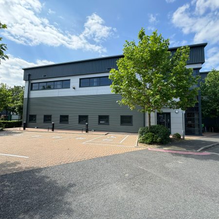 A warehouse building with trees in front of it, in Prologis Central Way, a park that offers modern industrial spaces.