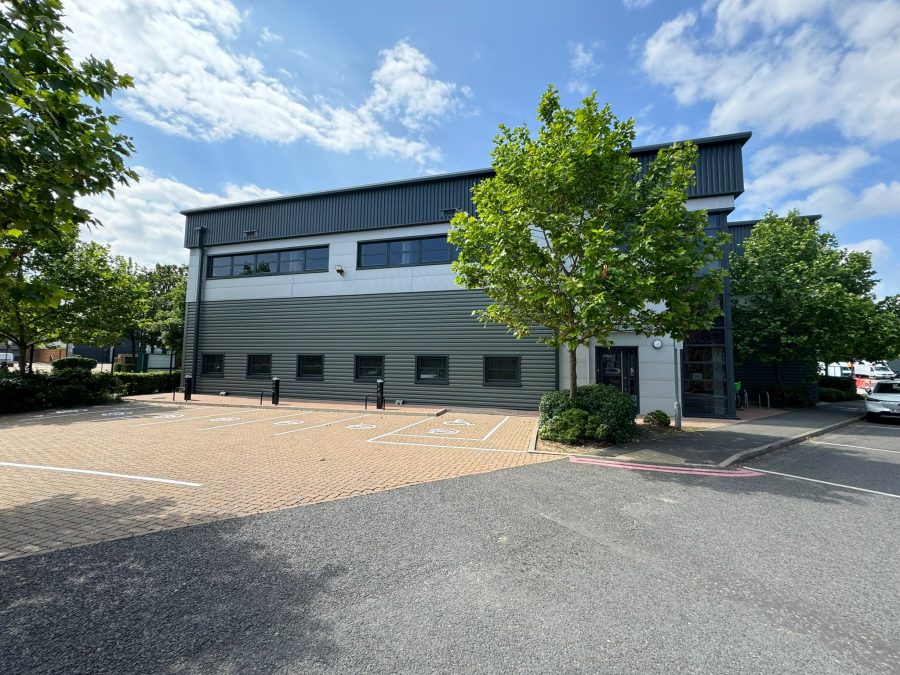 A warehouse building with trees in front of it, in Prologis Central Way, a park that offers modern industrial spaces.